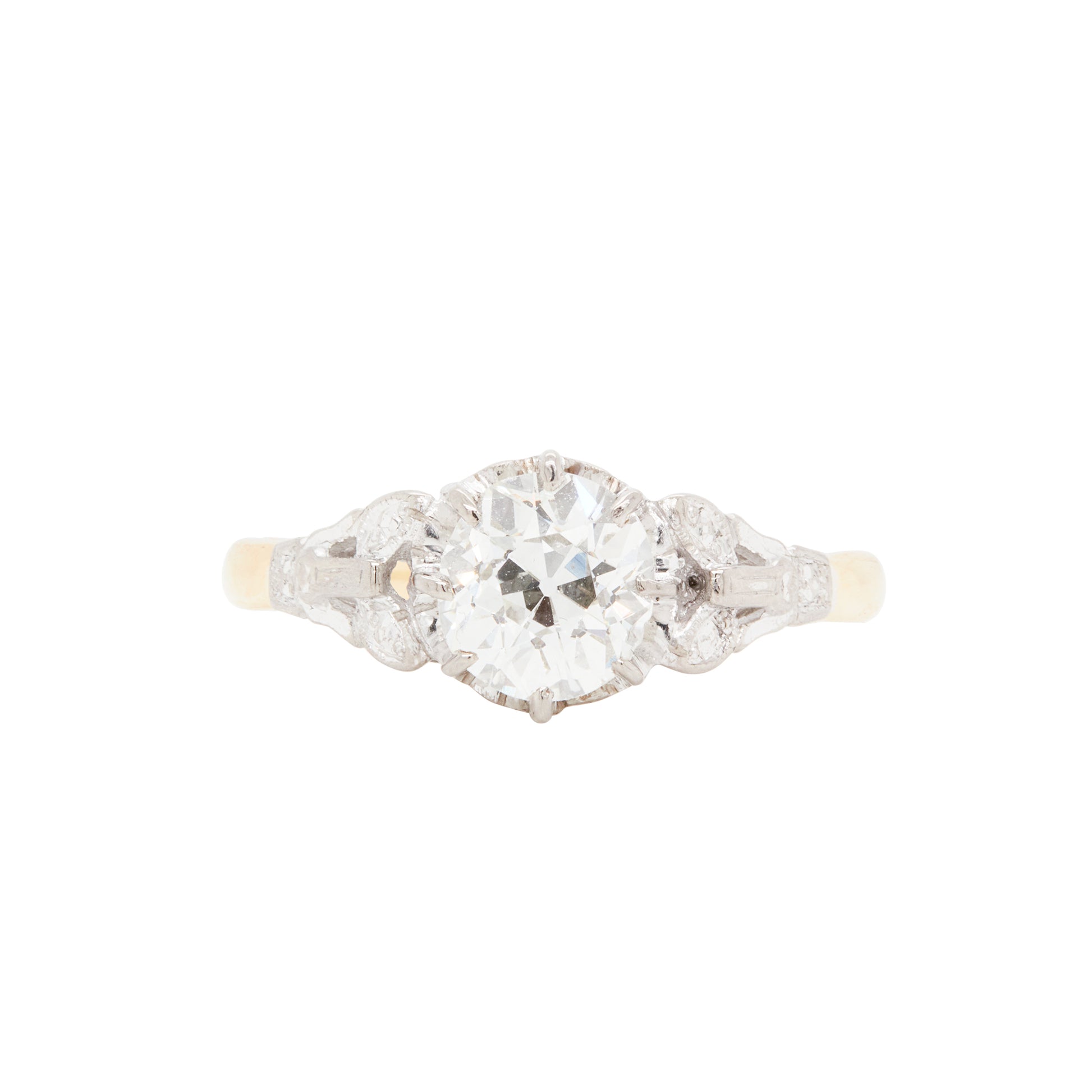 An antique Edwardian engagement ring featuring a 1.29ct old mine cut diamond in an elevated eight claw platinum setting with Art Deco motifs on the shoulders, complemented by a high polish 18 carat yellow gold band.