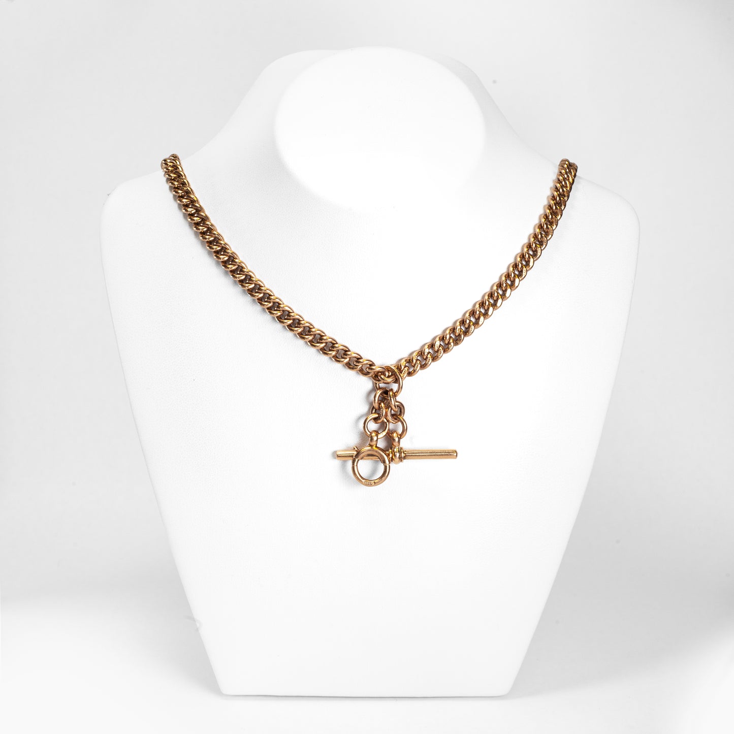 A rose gold antique Albert chain necklace with two lobster clasps and a T-bar and bolt ring.
