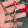A rose gold antique Albert chain necklace with two lobster clasps and a T-bar and bolt ring.