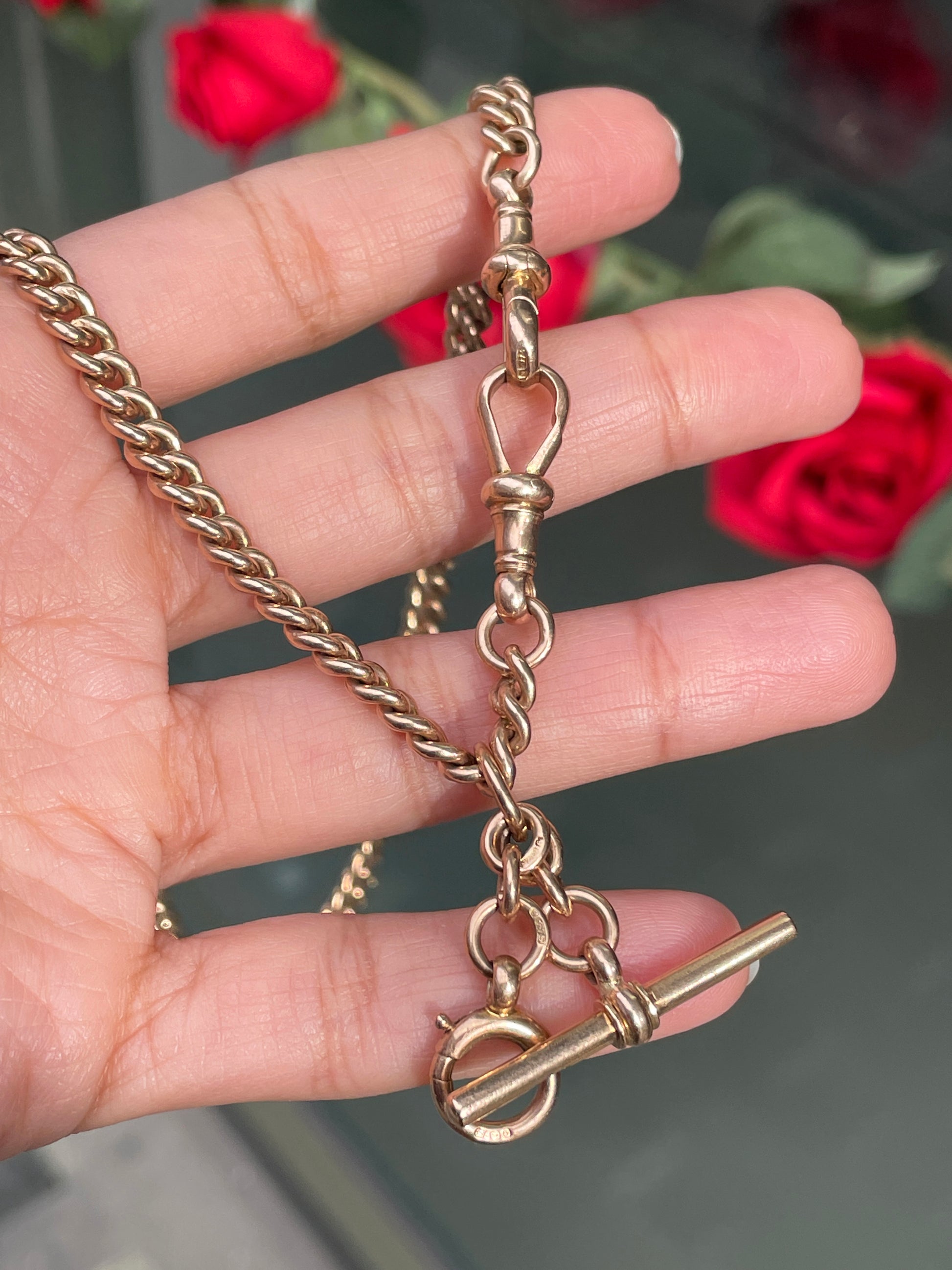 A rose gold antique Albert chain necklace with two lobster clasps and a T-bar and bolt ring.