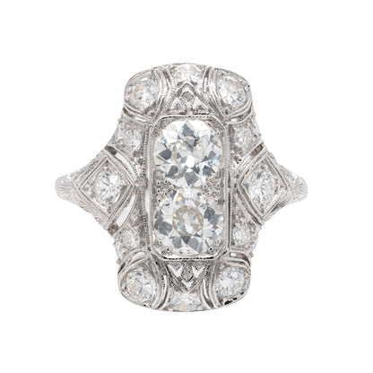 An antique Art Deco old mine cut diamond vertical platinum dress ring with smaller old European cut diamonds set in a rectangular panel with milgrain detailing.