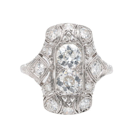 An antique Art Deco old mine cut diamond vertical platinum dress ring with smaller old European cut diamonds set in a rectangular panel with milgrain detailing.