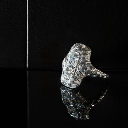 An antique Art Deco old mine cut diamond vertical platinum dress ring with smaller old European cut diamonds set in a rectangular panel with milgrain detailing.