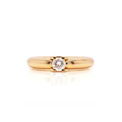 An 18 carat yellow gold Cartier 'C de Cartier' diamond solitaire engagement ring with a round brilliant cut center diamond.