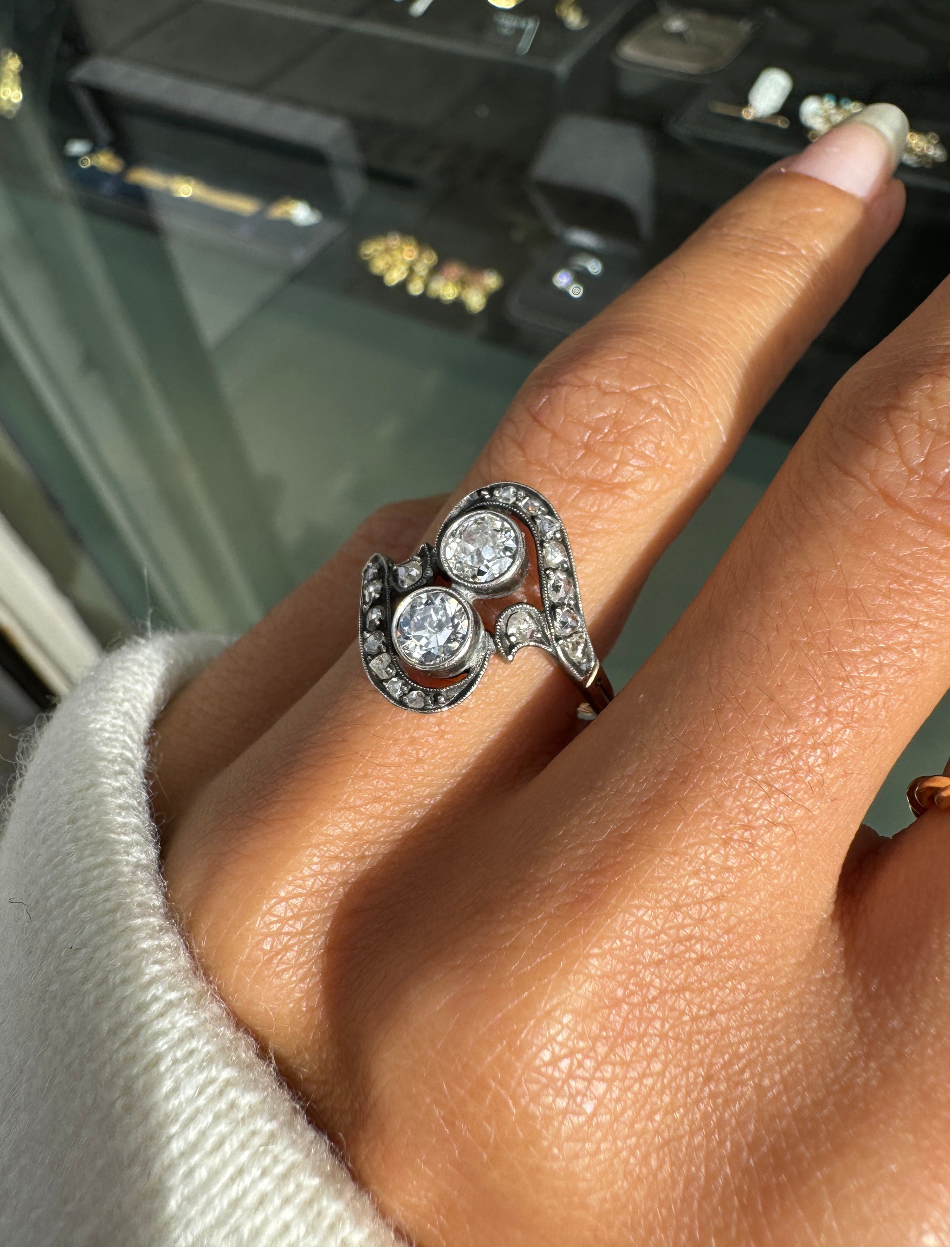 Close-up of a hand wearing a rose gold ring with multiple diamonds.