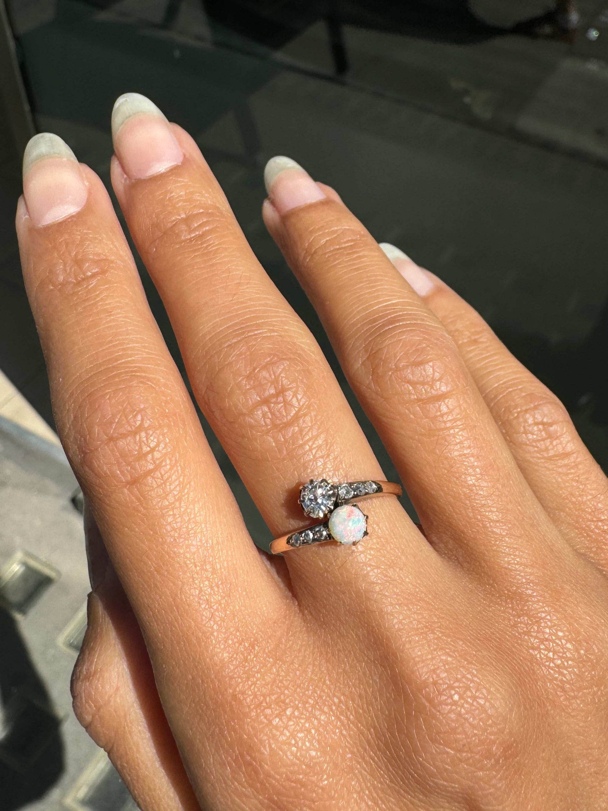 Hand wearing a ring with a clear stone on a dark background