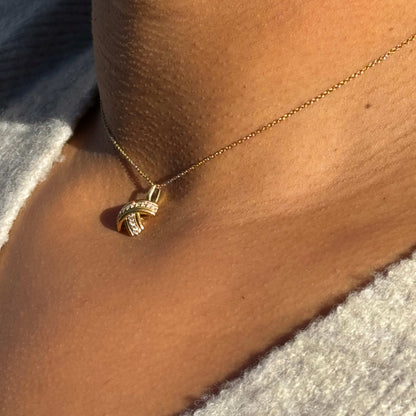 lady wearing Tiffany & Co. Signature X Diamond & 18 Carat Yellow Gold 'Kiss' Pendant Necklace close up