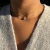 lady wearing Tiffany & Co. Signature X Diamond & 18 Carat Yellow Gold 'Kiss' Pendant Necklace 