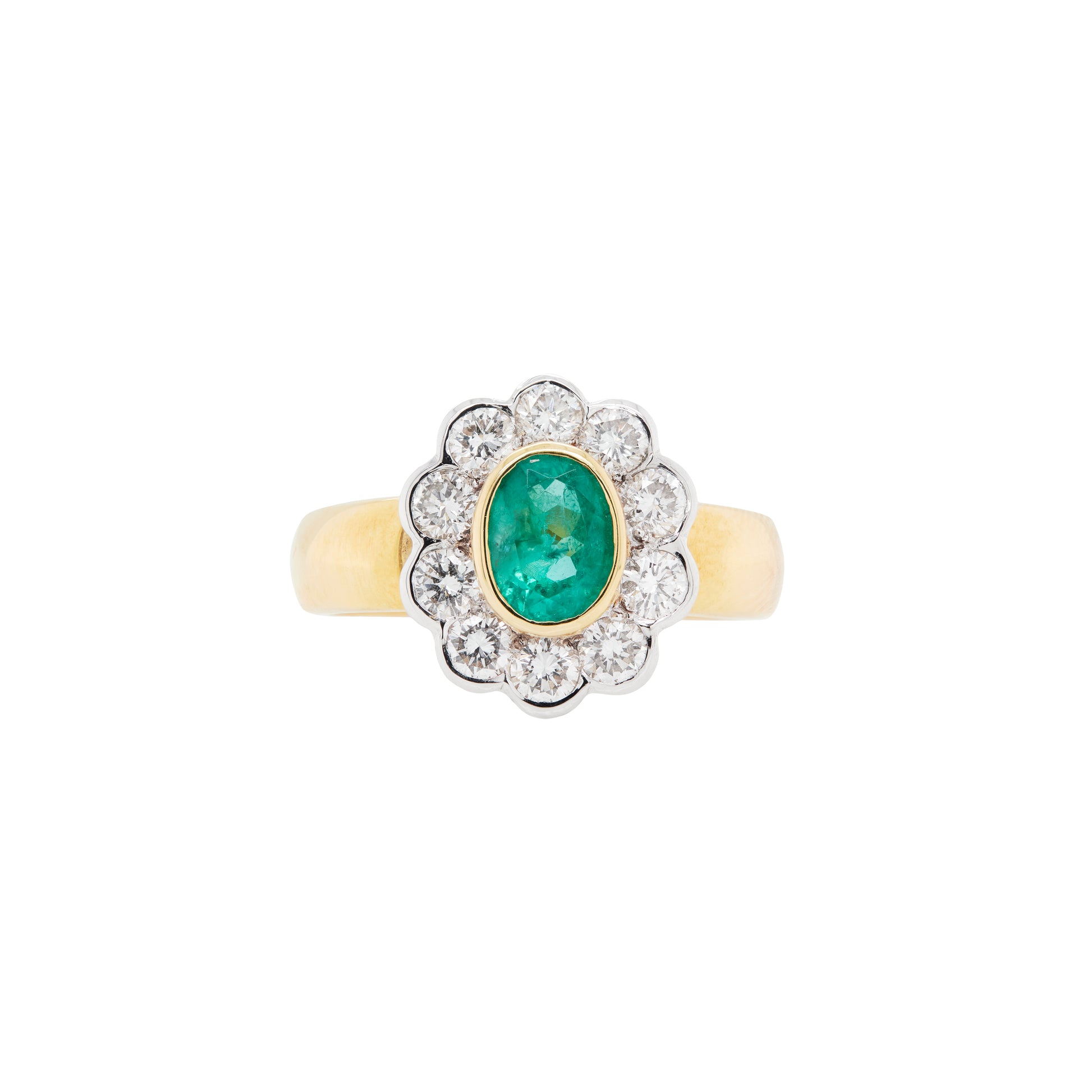An oval emerald ring with a diamond halo, set in a cluster design with yellow and white gold.