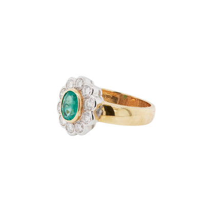 Gold ring with an emerald and diamond accents on a white background