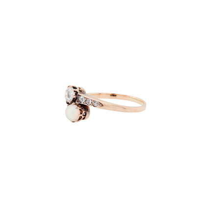 Gold ring with a pearl and small diamonds on a white background