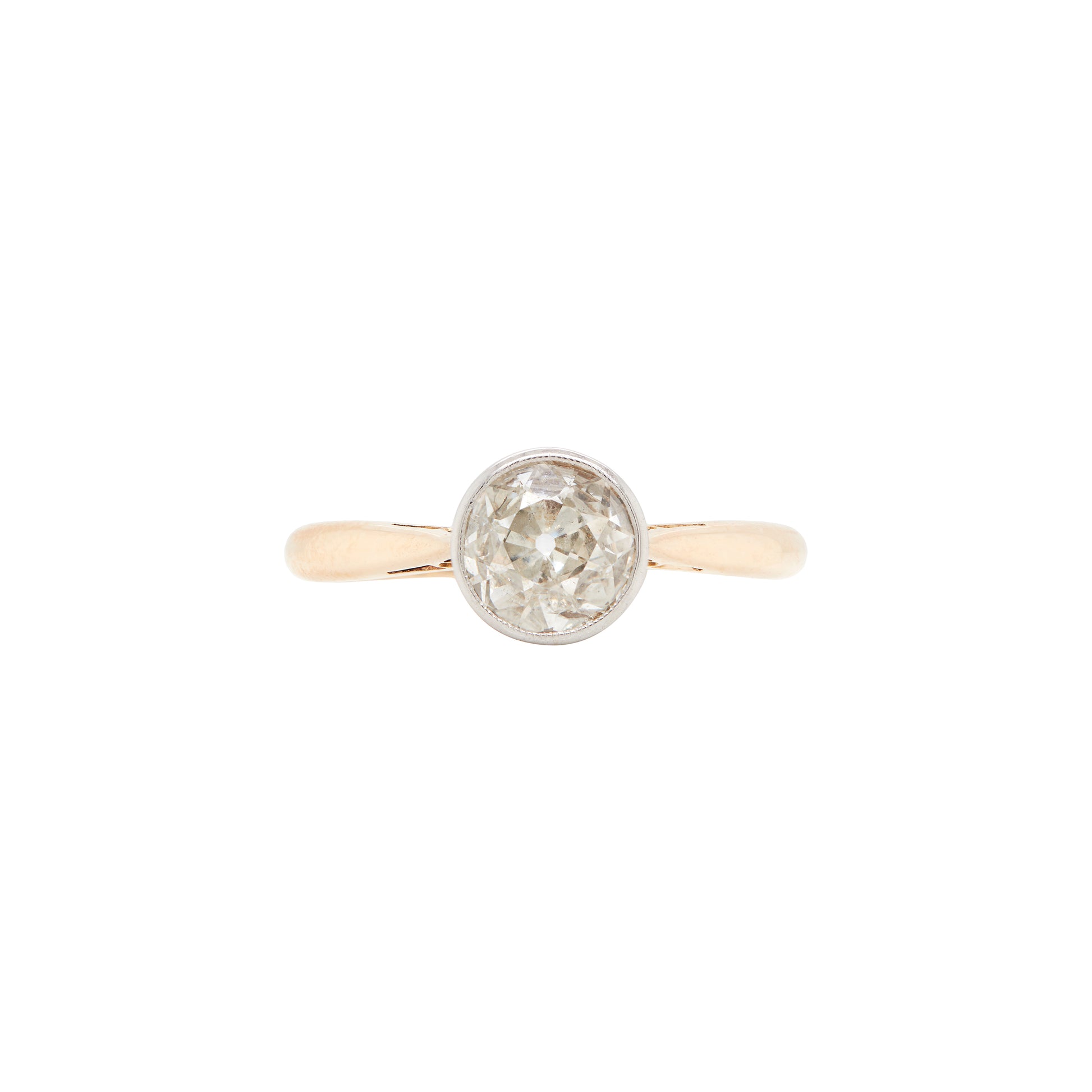 An Art Deco style solitaire diamond ring with a rub-over setting, featuring a millgrain edge on the band, photographed on a white background.