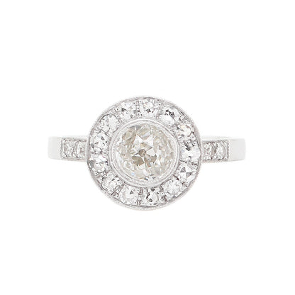 A vintage inspired round old cut diamond 18 carat white gold cluster ring with multiple smaller diamonds set around the central diamond.