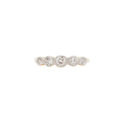 An 18 carat gold five-stone ring with old cut diamonds set in white gold bezels, featuring a yellow gold band.