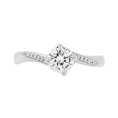 A twist engagement ring with a round brilliant cut diamond centerpiece and smaller round brilliant cut diamonds set in a twisted platinum mount.
