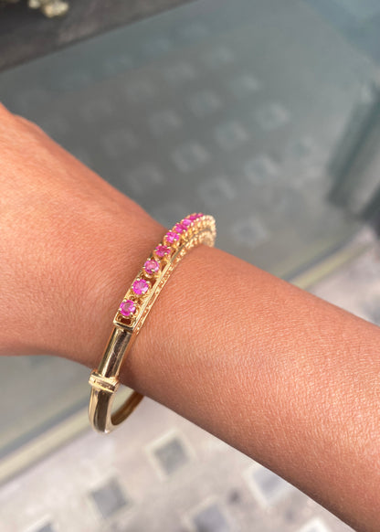 Vintage Ruby and 14 Carat Yellow Gold Open Work Hinged Bangle, circa 1980s