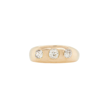 An 18K yellow gold gents three-stone ring with three old mine cut diamonds set in open back settings.