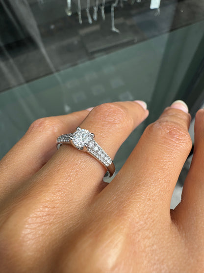Close-up of a hand wearing a diamond ring with a blurred background