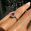 Close-up of a hand wearing a antique ruby ring with a red gemstone on a blurred background