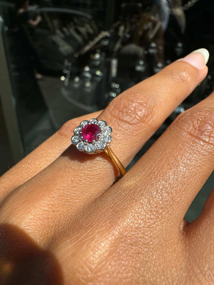 Close-up of a hand wearing a antique ruby ring with a red gemstone on a blurred background