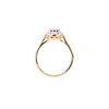 Gold ring with a central gemstone and smaller stones on a white background - side view