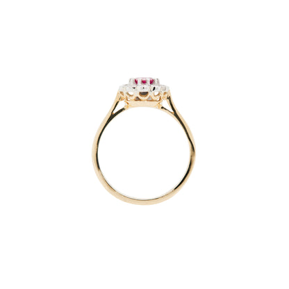Gold ring with a central gemstone and smaller stones on a white background - side view