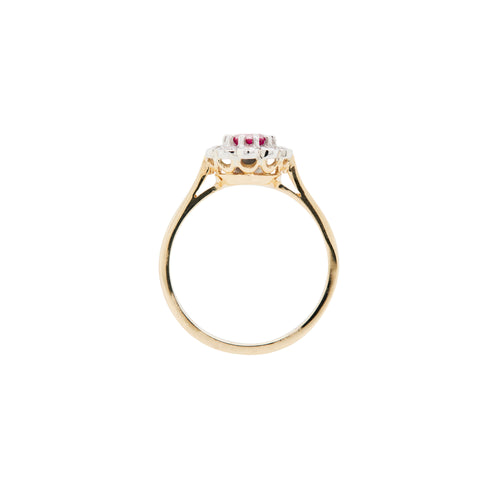 Gold ring with a central gemstone and smaller stones on a white background - side view