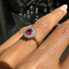 Close-up of a hand wearing a antique ruby ring with a red gemstone on a blurred background