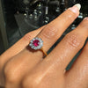 Close-up of a hand wearing a antique ruby ring with a red gemstone and diamond accents.