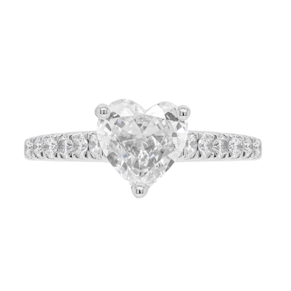 A heart-shaped diamond engagement ring with smaller round brilliant cut diamonds set in a platinum band.