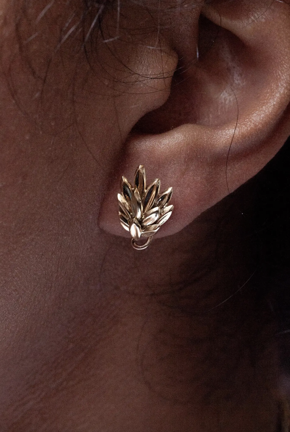 lady wearing a leaf motif 18 carat gold earring