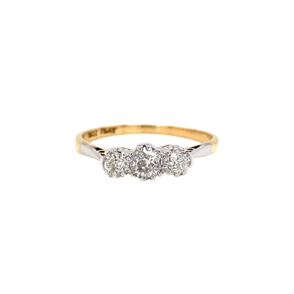 An 18 carat yellow gold and platinum three-stone engagement ring with old cut diamonds set in open back platinum settings.