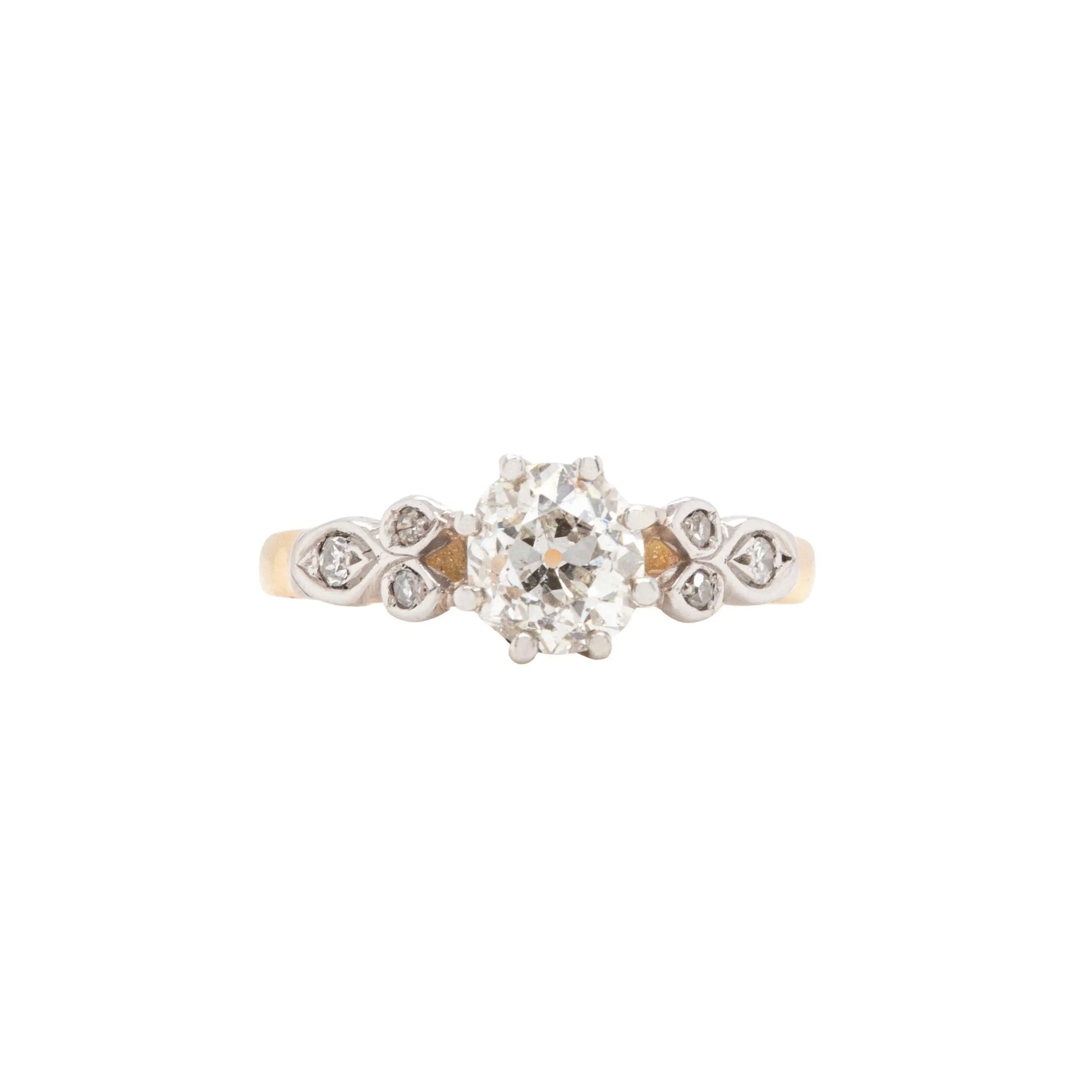 An 18K white gold and platinum engagement ring with a central old mine cut diamond and surrounding smaller diamonds.