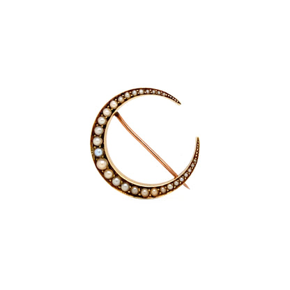 An antique seed pearl and 14 carat yellow and rose gold crescent brooch with a brooch pin and hook on the back.