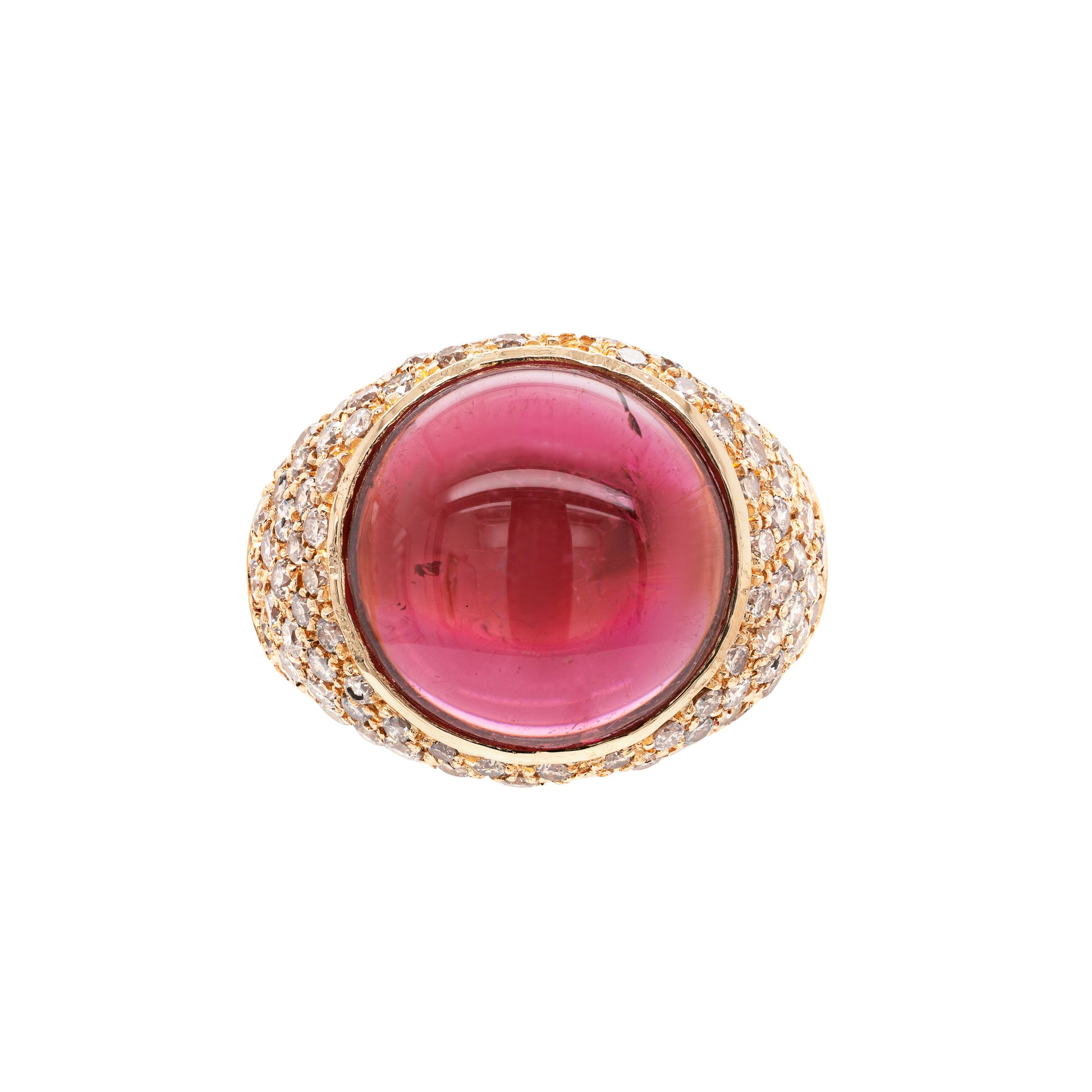 A vibrant pink cabochon tourmaline cocktail ring with a yellow gold band and round brilliant cut diamonds set around the top.