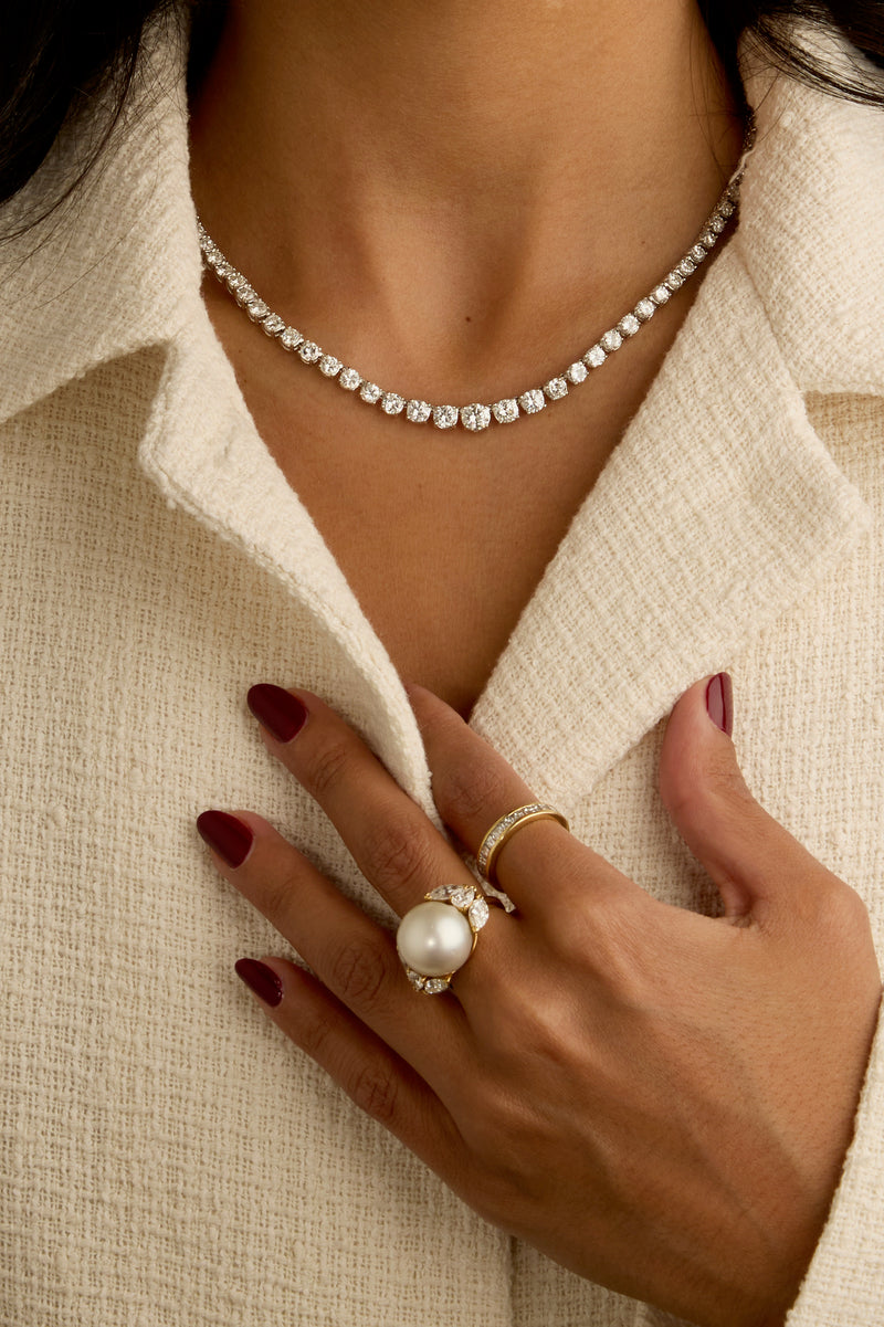 a woman wear diamond tennis necklace and pearl diamond rings