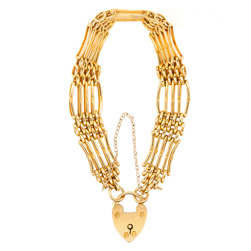 An 18 carat yellow gold bracelet with a heart-shaped padlock gate, featuring a series of linked segments.
