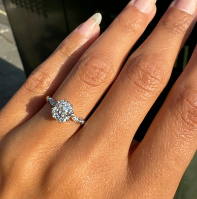 engagement ring with a old mine cut diamond on a hand against a blurred background