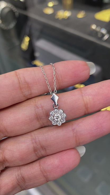 Video of a 0.45 carat diamond flower cluster pendant crafted in 18 carat white gold, round brilliant cut diamonds arranged in a floral design, suspended from a delicate white gold chain. on hand
