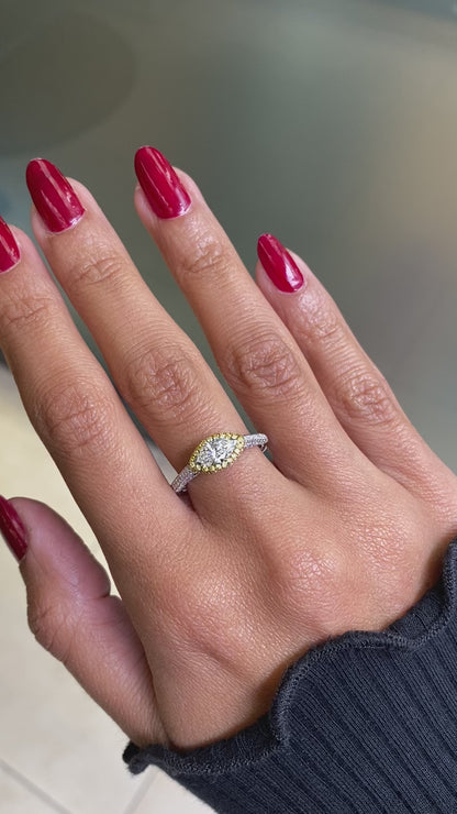 Video of a marquise diamond engagement ring with an east west setting  halo of round yellow diamonds set in rose gold, with smaller white round brilliant cut diamonds set in a contrasting band of platinum. on hand