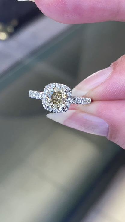 A champagne diamond engagement ring with white round brilliant cut diamonds set in a platinum band.