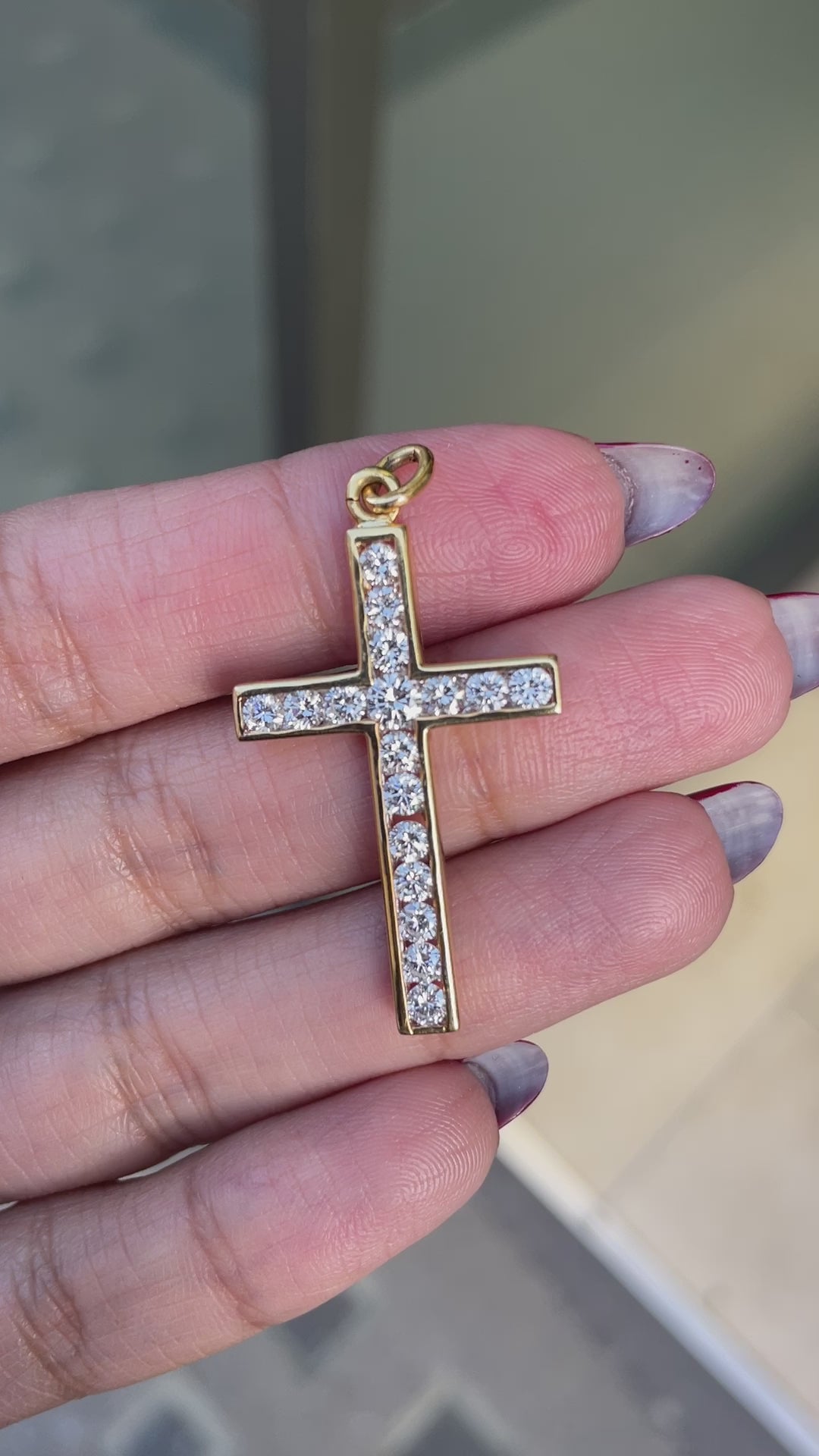 An 18 carat yellow gold diamond cross pendant with multiple round brilliant cut diamonds set within it.