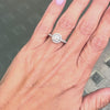 0.70ct E VS1 diamond halo cluster engagement ring in platinum with round brilliant cut centre stone, halo and diamond shoulders on hand