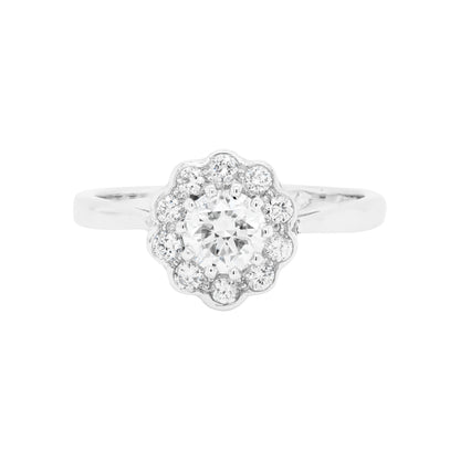 A round brilliant cut diamond ring with smaller round brilliant cut diamonds set in a daisy cluster design, mounted in a platinum band.