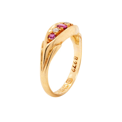 side view An 18 carat yellow gold five-stone ring with three round rubies and two old cut diamonds set in the band.